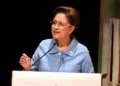 Prime Minister Kamla Persad-Bissessar speaks at a podium as Trinidad Declares State of Emergency