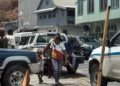 Police and residents at the scene of the Leslie Land triple shooting in Castries where three men were injured