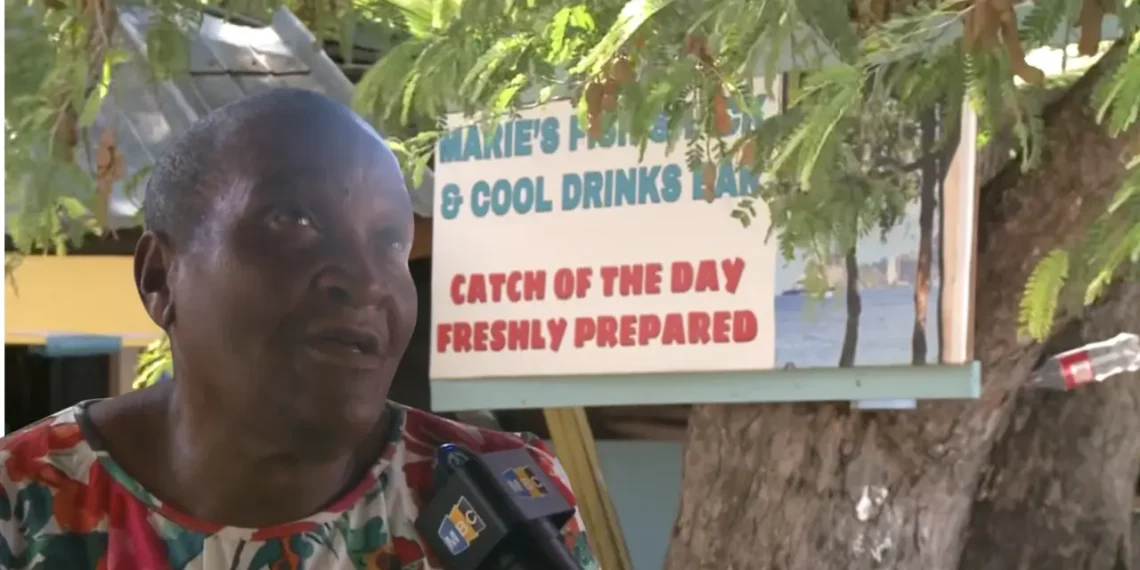Marie Fish Shack eviction dispute as Marie speaks during an interview in front of her sign at Reduit Beach in St Lucia