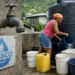 St Lucia Water Crisis image shows a resident filling buckets beside a WASCO water tank during prolonged outages