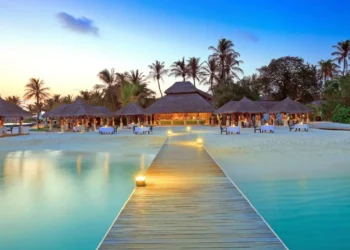 Caribbean tourism growth reflected in luxury beach resort at sunset