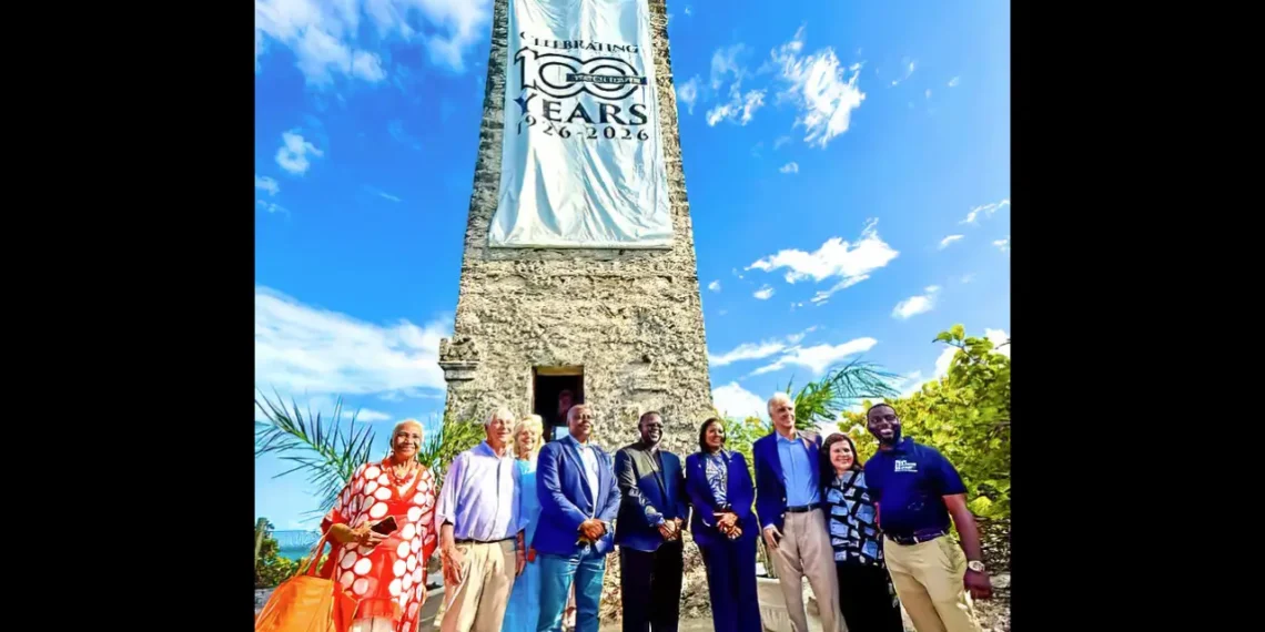 Blue Lagoon Watch Tower 100th Anniversary ceremony in Nassau Bahamas with officials gathered beneath the historic tower and commemorative banner