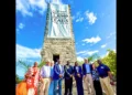 Blue Lagoon Watch Tower 100th Anniversary ceremony in Nassau Bahamas with officials gathered beneath the historic tower and commemorative banner