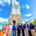 Blue Lagoon Watch Tower 100th Anniversary ceremony in Nassau Bahamas with officials gathered beneath the historic tower and commemorative banner