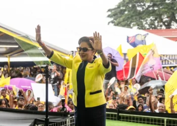 Kamla Persad-Bissessar raises both hands before supporters at a Trinidad rally as a letter to the editor addresses a Kamla Persad-Bissessar smear campaign.