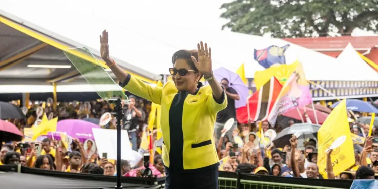 Kamla Persad-Bissessar raises both hands before supporters at a Trinidad rally as a letter to the editor addresses a Kamla Persad-Bissessar smear campaign.