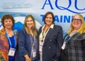 Aquila founder Beth Hatt and Vice President Melanie Colpitts with cruise executives at Seatrade Cruise Global 2026