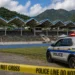 Illustration of Soufriere Stadium shooting scene with police tape and a police vehicle outside the Mini Stadium following the attack that injured two men