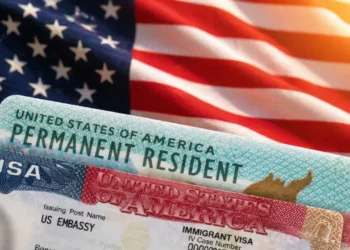 US Permanent Resident green card and immigrant visa documents on American flag background