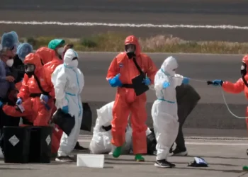 MV Hondius passengers sprayed with disinfectant by Spanish officials at Tenerife airport during the hantavirus cluster response.