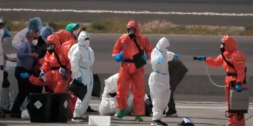 MV Hondius passengers sprayed with disinfectant by Spanish officials at Tenerife airport during the hantavirus cluster response.