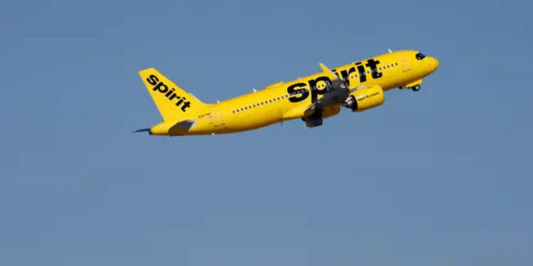 A Spirit Airlines aircraft climbs after takeoff against a clear blue sky, May 2026.