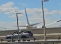 United Flight 169 Boeing 767 flying low over New Jersey Turnpike highway traffic and light poles on final approach to Newark Liberty International Airport.