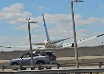 United Flight 169 Boeing 767 flying low over New Jersey Turnpike highway traffic and light poles on final approach to Newark Liberty International Airport.
