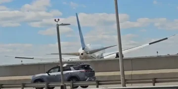 United Flight 169 Boeing 767 flying low over New Jersey Turnpike highway traffic and light poles on final approach to Newark Liberty International Airport.