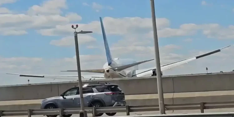 United Flight 169 Boeing 767 flying low over New Jersey Turnpike highway traffic and light poles on final approach to Newark Liberty International Airport.