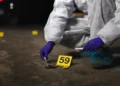 St Lucia national killed — illustrative image of forensic investigator collecting evidence at night crime scene
