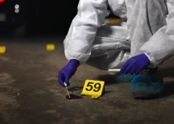 St Lucia national killed — illustrative image of forensic investigator collecting evidence at night crime scene