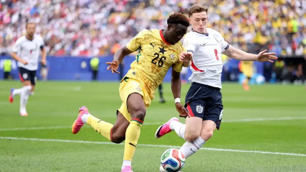 Ghana player number 26 drives forward under pressure from England number 8 during the 0-0 draw at the 2026 FIFA World Cup in Boston