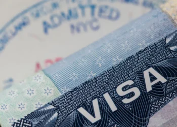 A U.S. visa document and entry stamp illustrating U.S. visa revocations tied to fraud and Medicaid abuse