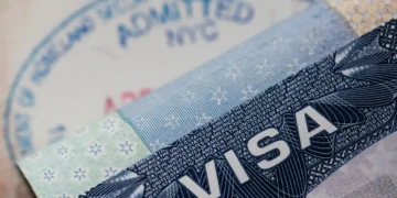 A U.S. visa document and entry stamp illustrating U.S. visa revocations tied to fraud and Medicaid abuse