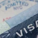 A U.S. visa document and entry stamp illustrating U.S. visa revocations tied to fraud and Medicaid abuse