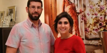 The Hadeeds, Dominic and Genevieve, standing together indoors and smiling for a photo.