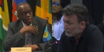 Split image of Prime Minister Philip J. Pierre seated at a CARICOM chairman's desk and Al Jazeera correspondent Josh Rushing speaking at a microphone.