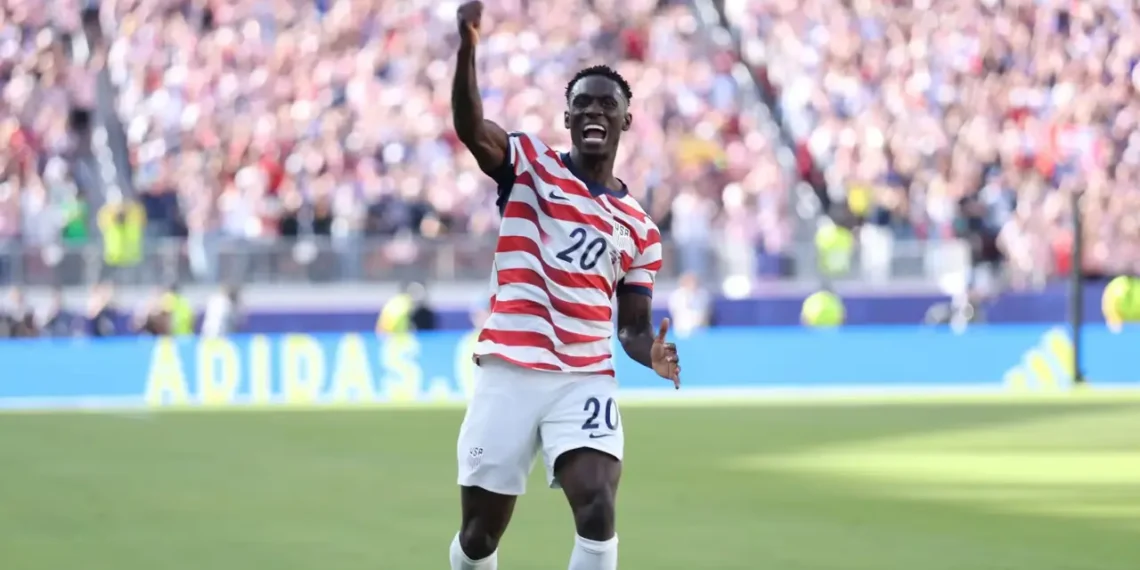 USMNT forward Folarin Balogun celebrating a goal in a US jersey during the 2026 World Cup.