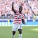 USMNT forward Folarin Balogun celebrating a goal in a US jersey during the 2026 World Cup.