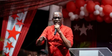 Prime Minister Philip J. Pierre, wearing a red shirt, addresses supporters during Five Years of SLP Rule in Saint Lucia.