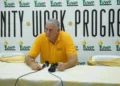 Allen Chastanet seated before a UWP Unity, Work, Progress backdrop as commentary examines UWP internal divisions and party leadership.
