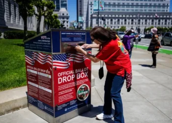 Voter deposits a ballot into an official San Francisco drop box, illustrating the California ballot ruling dispute.