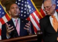 Hakeem Jeffries speaks beside Chuck Schumer with U.S. flags behind them, pictured in coverage of the lawsuit challenging voter purge demands.