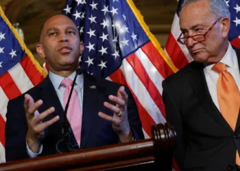 Hakeem Jeffries speaks beside Chuck Schumer with U.S. flags behind them, pictured in coverage of the lawsuit challenging voter purge demands.