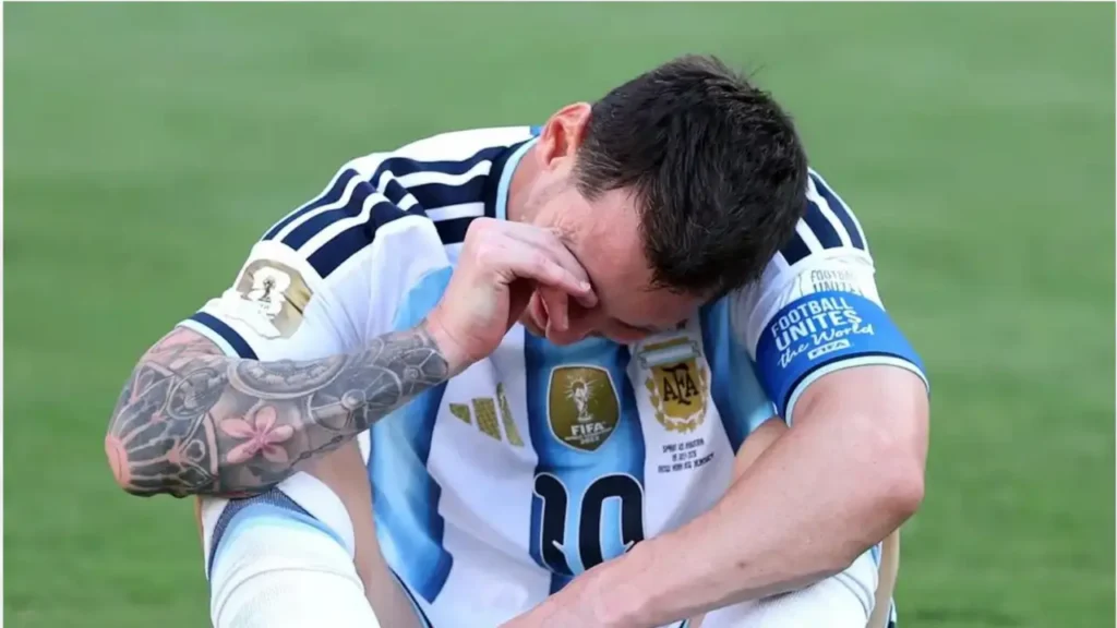 Lionel Messi sits emotional on the pitch in Argentina's No. 10 shirt during his international career